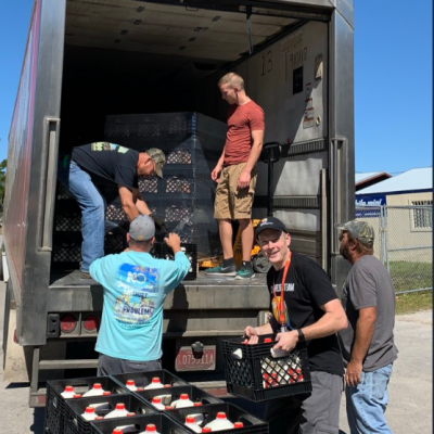 World Central Kitchen volunteers help unload the first truck of Borden Dairy products.